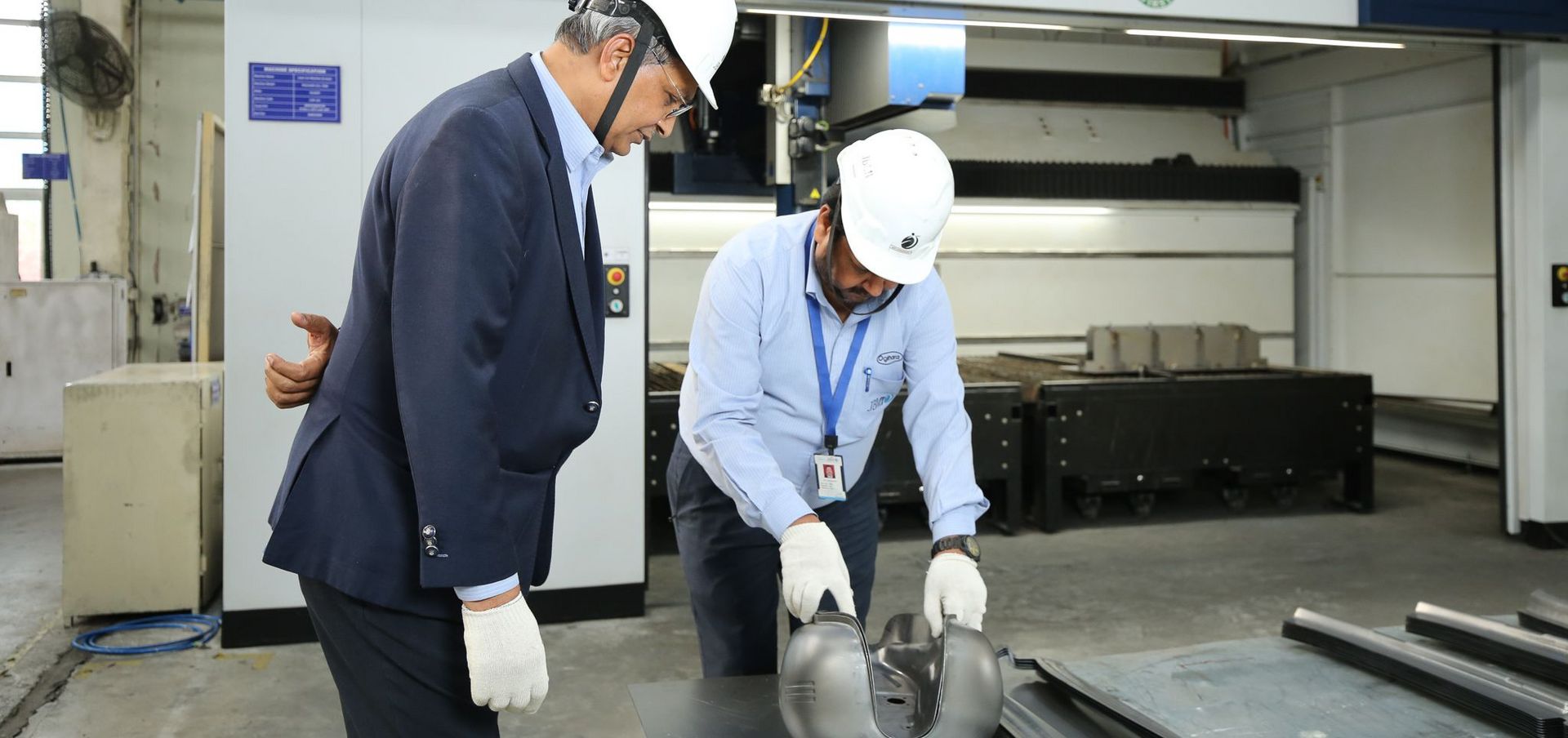 Die Bauteile aus hochfestem Stahl sind präzise bearbeitet, wie Ajit Choudhary, General Manager bei JBM Auto Components, dem Präsidenten Strategy & Business Planning des Unternehmens, B. B. Gupta, demonstriert.