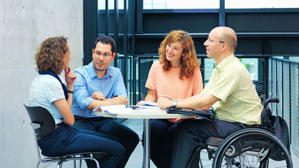 Des employés de TRUMPF discutent. Il y a un employé handicapé dans le groupe