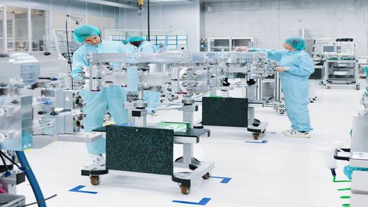 Empleados de TRUMPF trabajando en la sala blanca en el montaje del resonador láser.