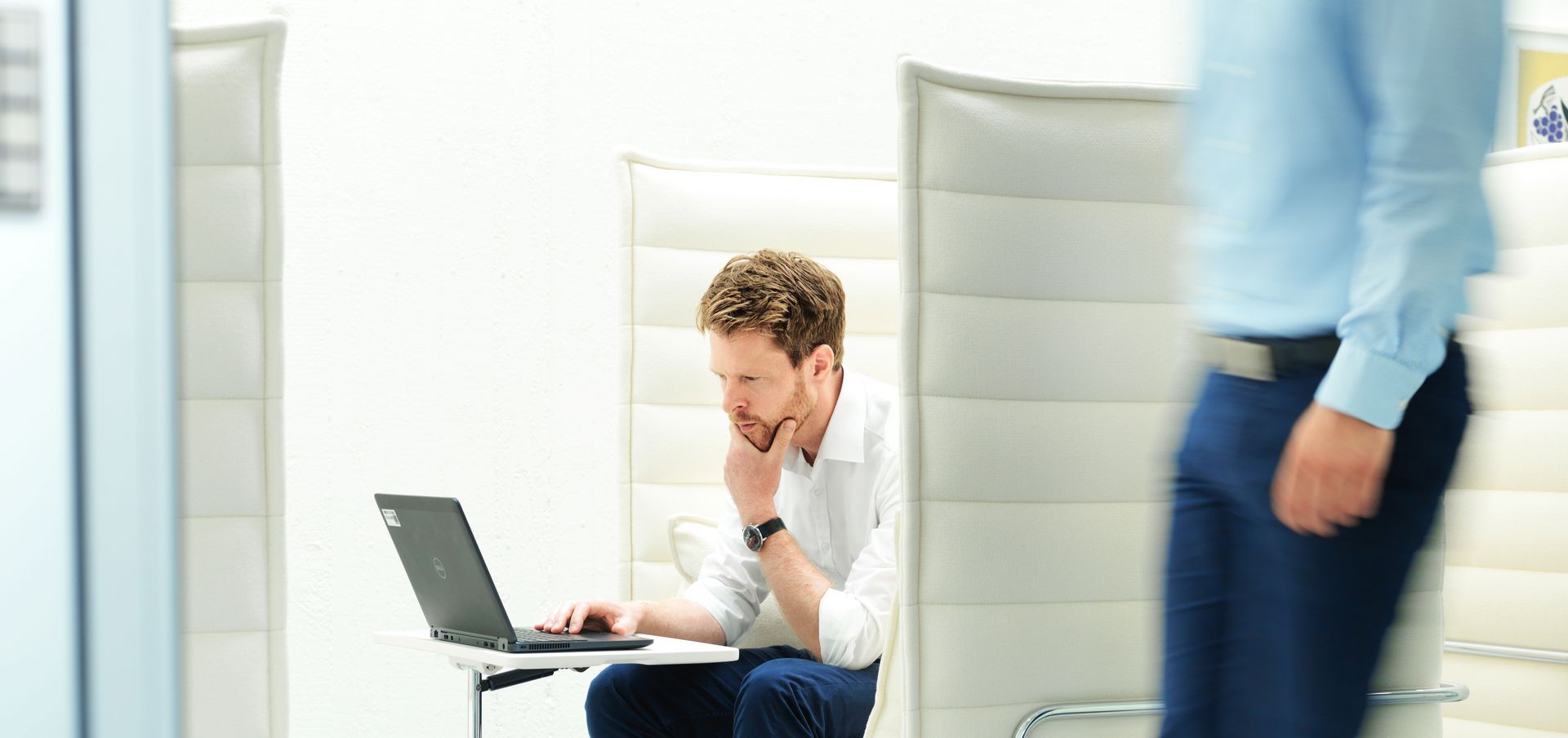 TRUMPF employee is working in the lounge area on his laptop