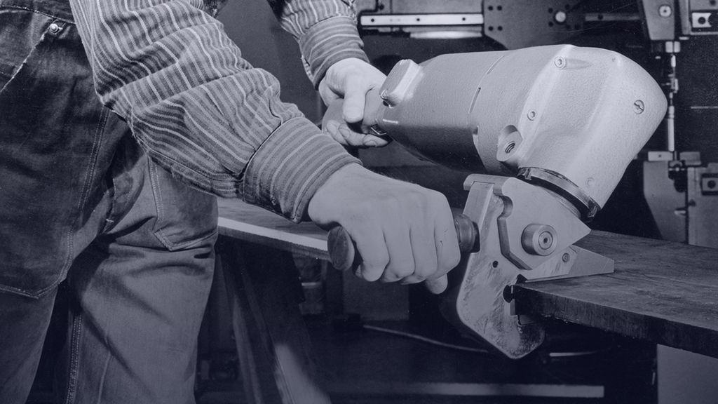 historical picture showing a worker with a deburrer
