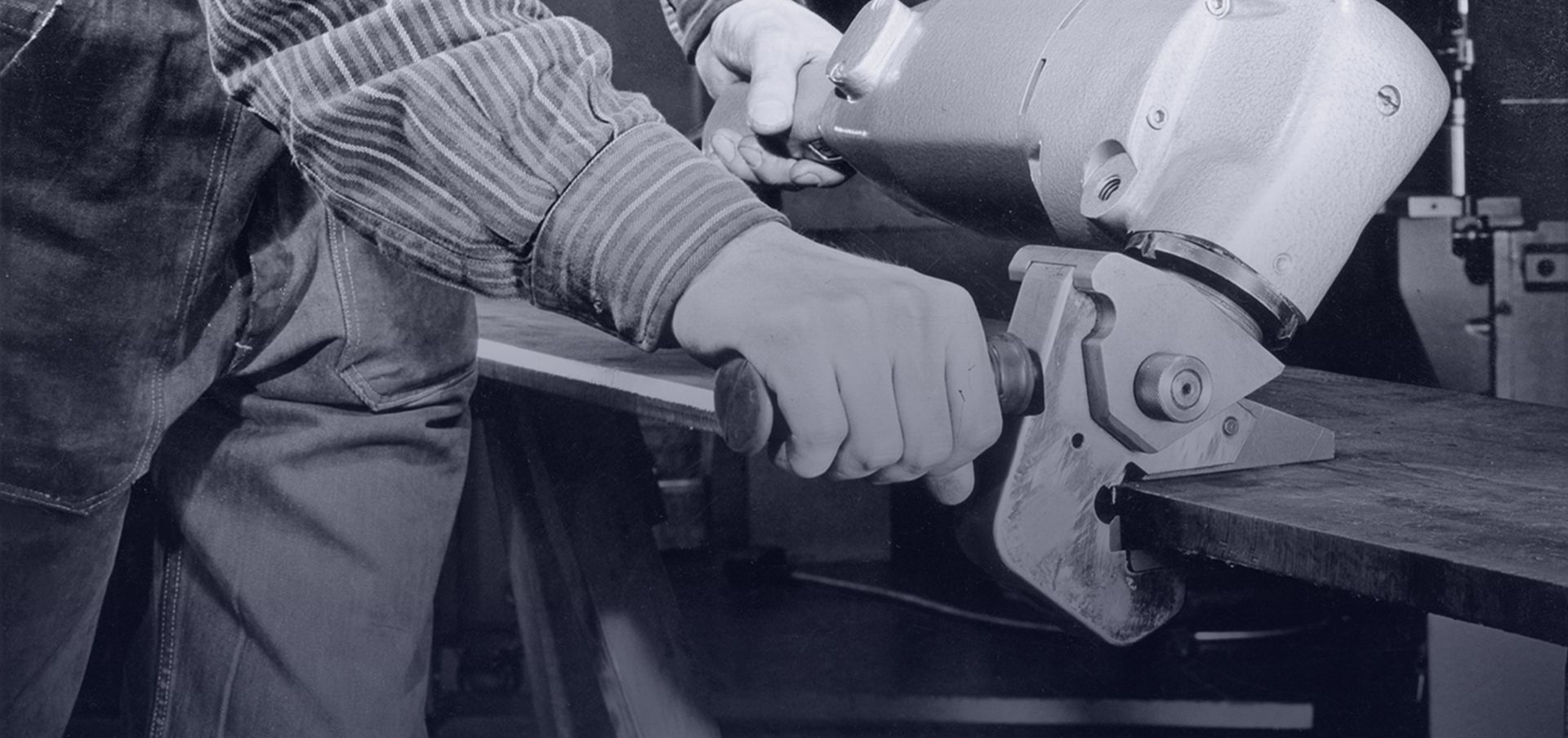 Photo historique représentant un opérateur avec une ébavureuse