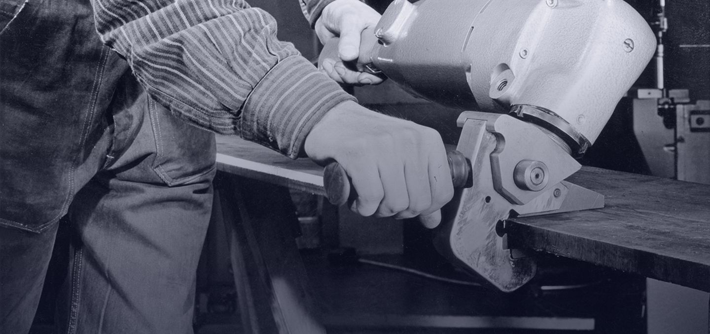 imagem histórica mostrando um funcionário com uma rebarbadora