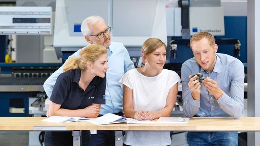 TRUMPF employees talking about a sample part