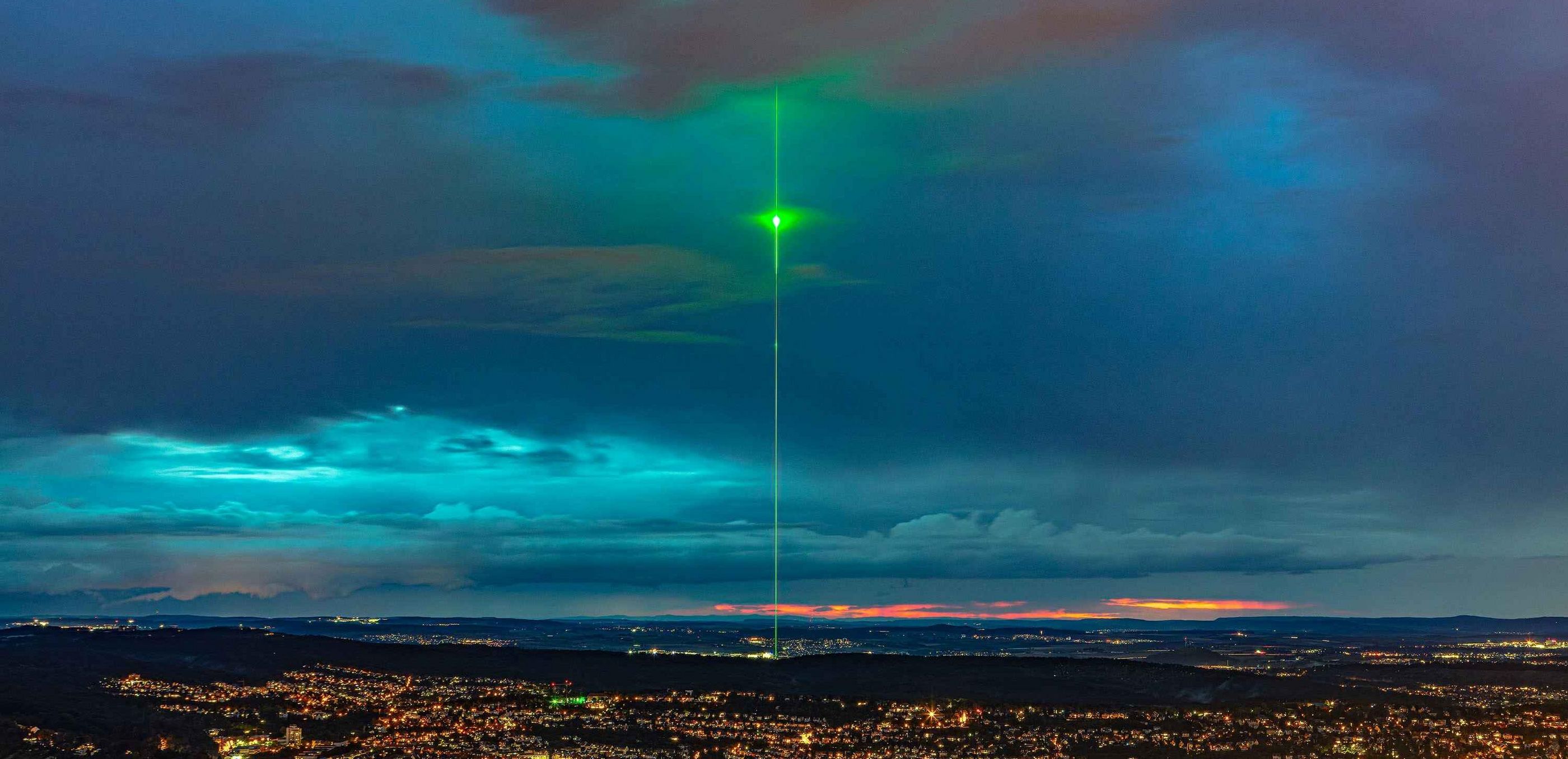 Un laser de spectacle vert s'élève dans le ciel au-dessus de l'usine TRUMPF de Ditzingen